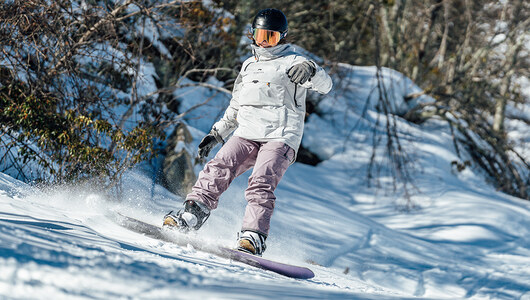 A guest snowboarding on the ski slopes at Massanutten Resort