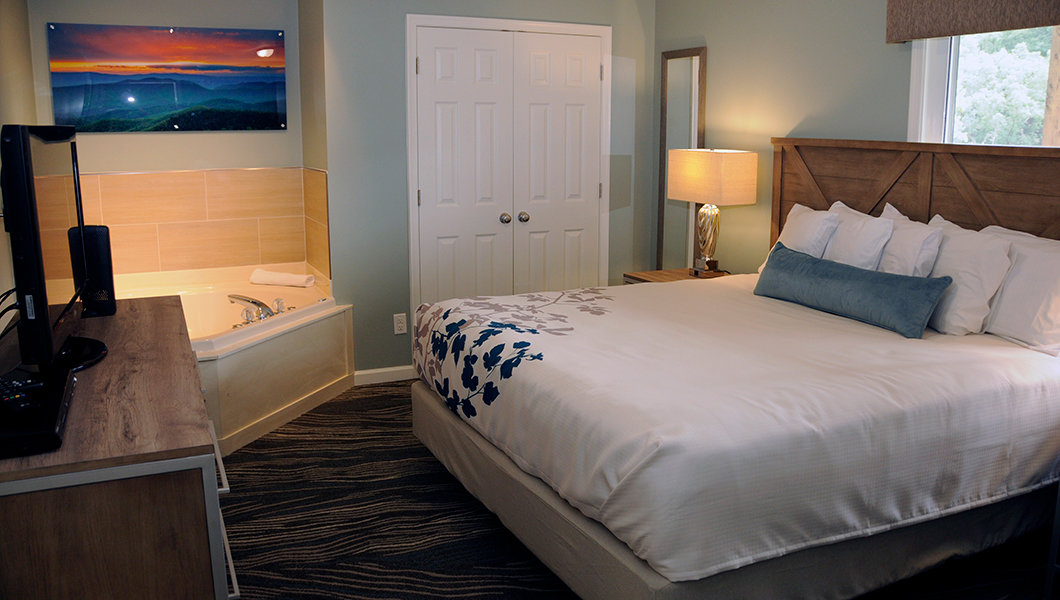 Woodstone Casa condo bedroom with king bed and whirlpool tub in corner of room
