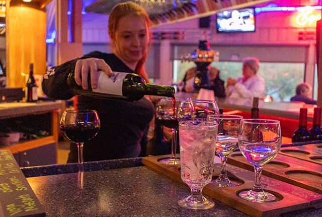 Employee pouring a glass of red wine
