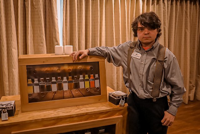 An employee standing by the drinks menu